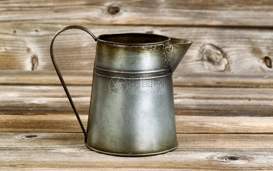古老的金属咖啡壶在生锈的木头上图片