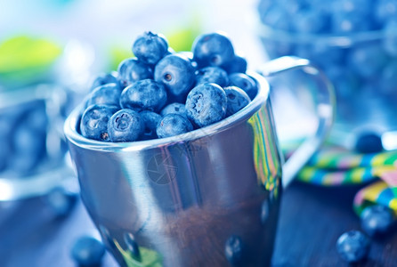 桌子上的新鲜蓝莓木制背景的蓝莓图片