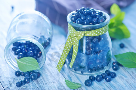 玻璃和桌子上新鲜的蓝莓图片