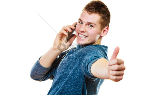 青年男子在手机上闲谈时使用智能手机做拇指手势在白色和上隔离图片
