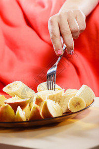 人类女用手抢香蕉和苹果水在盘子上健康营养饮食和瘦化概念图片
