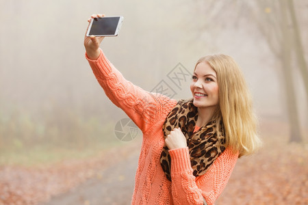 秋天公园的快乐时装女郎拍了自照片穿着毛衣的很快乐年轻女孩图片