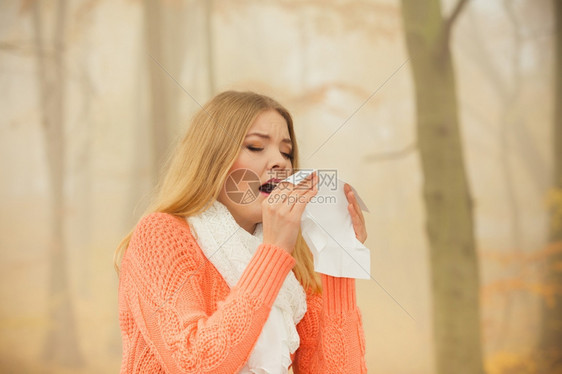秋天公园的生病妇女打喷嚏图片
