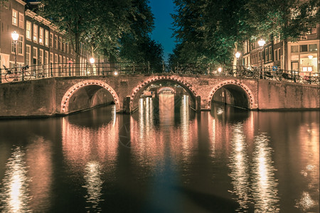 荷兰阿姆斯特丹运河和七座桥梁的夜间城市景色图片