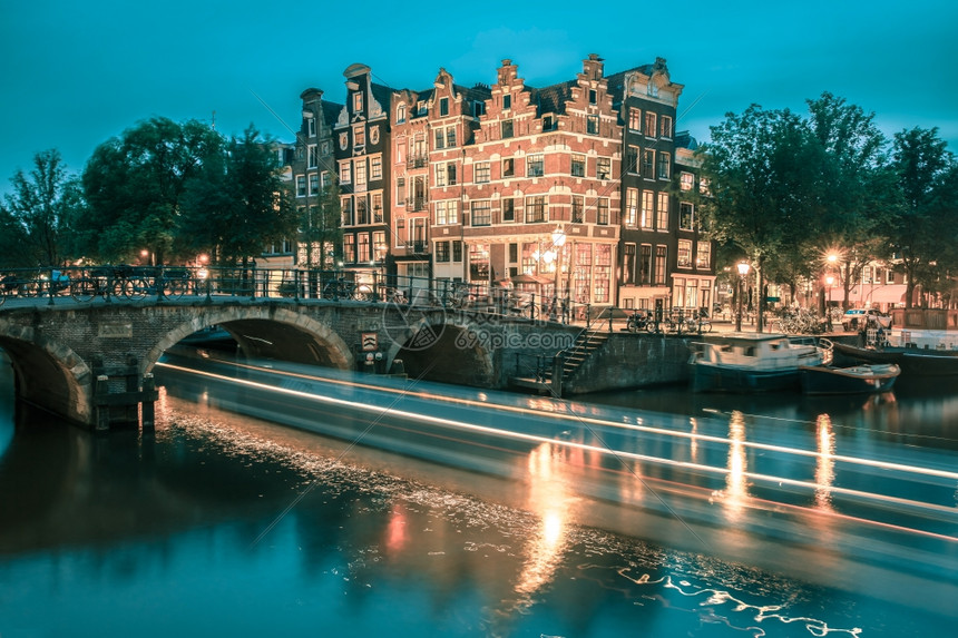阿姆斯特丹运河桥梁和典型房屋船只和自行车的夜间城市景色荷兰图片