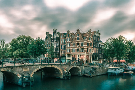 阿姆斯特丹运河桥梁典型房屋船只和自行车荷兰的黄昏城市风景图片