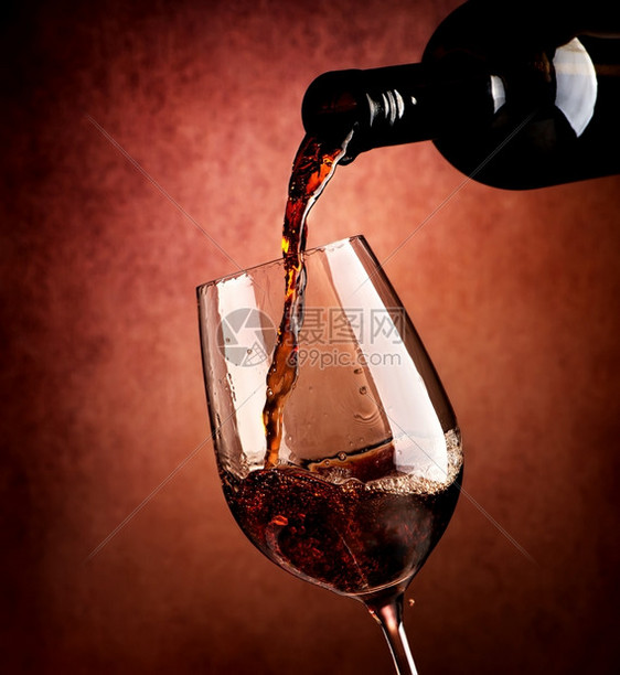 棕色背景的葡萄酒倒在杯里图片