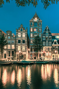 荷兰阿姆斯特丹运河赫林格拉特典型的荷兰码头房屋和船只夜景城市色背景图片