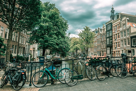 阿姆斯特丹运河和典型房屋船只和自行车的城市景象荷兰背景图片