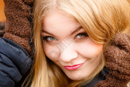 开心的女士穿着时装的冬衣戴大手套盖着耳朵图片