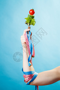 饮食和减肥概念糖尿病女手与素食和彩色测量磁带蓝背景图片