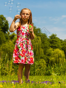 小女孩在户外吹泡小孩在公园玩得开心快乐和无忧虑的童年图片