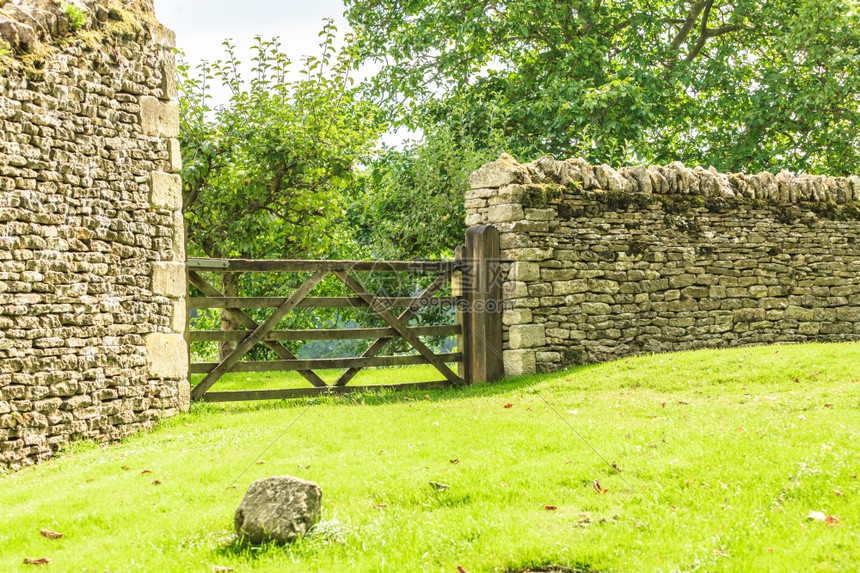 自然夏季风景英国BiburyEngland村干岩墙上的乡村景色和锈铁门图片