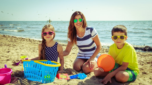 快乐的家庭在沙滩上玩得开心图片