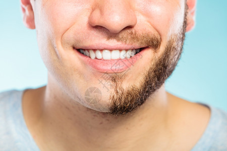 半剃刮脸胡子头发的快乐男人半剃脸胡子头发的快乐男人蓝色的笑脸男人皮肤护理和卫生图片