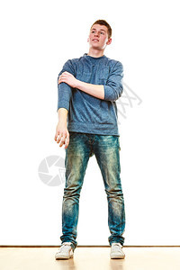 年轻时尚的男少年孩穿着全长的散闲风格穿着蓝色牛仔裤穿着白色的孤立裤图片