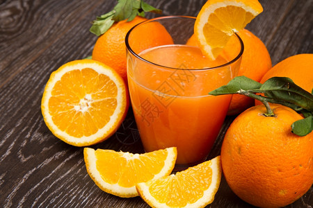 鲜橙汁和木底子的玻璃杯图片