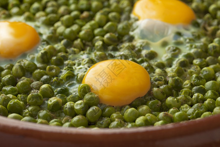 摩洛哥的塔吉尼配青豆和阳光明媚的一面紧闭鸡蛋图片