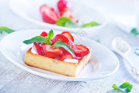 白盘上加草莓的蛋糕图片
