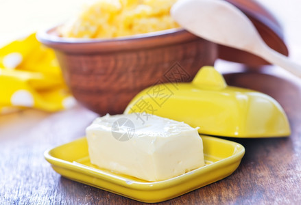 玉米粥和木制桌上的黄油图片