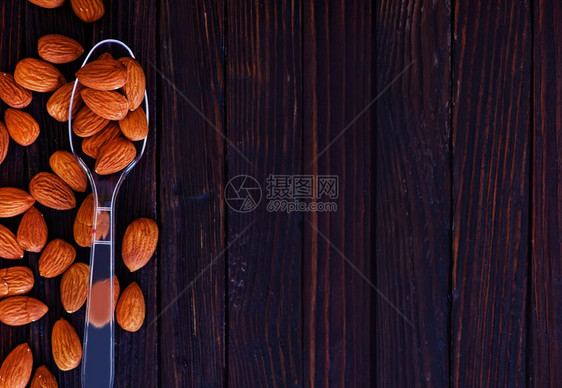 用勺子和桌上的杏仁干图片