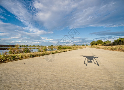 无人驾驶的六氯丁二烯影子低空飞行与摄像头对着混凝土自行车足迹图片