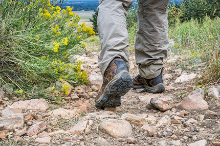 男脚踏着皮靴登上山丘的足迹图片
