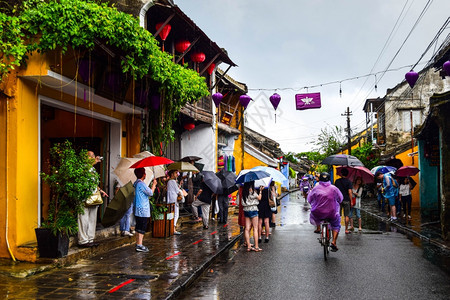 旅游观光客在一个古老的小镇在雨天行走图片