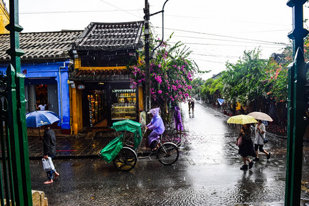 旅游观光客在一个古老的小镇在雨天行走图片