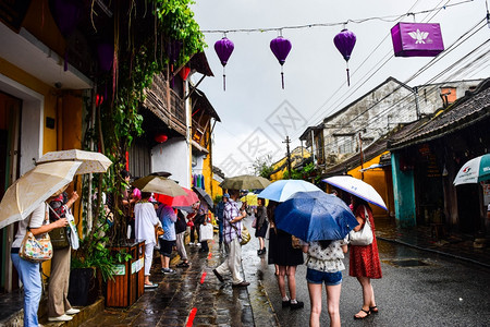 旅游观光客在一个古老的小镇在雨天行走图片