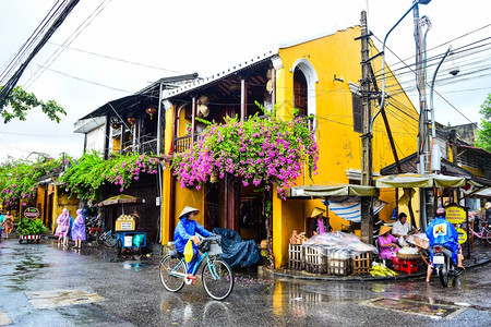 旅游者在雨天乘自行车参观霍伊古城图片