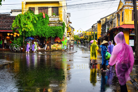 旅游观光客在一个古老的小镇在雨天行走图片