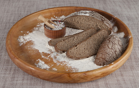 新鲜自制面包用杜伦麦制成黑用一罐盐的木盘在美丽的桌布上制成关于烹饪美食的杂志照片图片