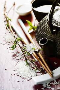 茶套棍棒和木制桌上的樱树枝图片
