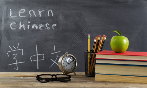 学生习中文有书籍铅笔时钟眼镜和苹果图片
