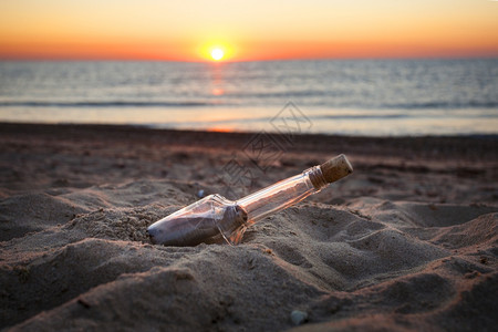 日落时在海滩上瓶子里写着信图片