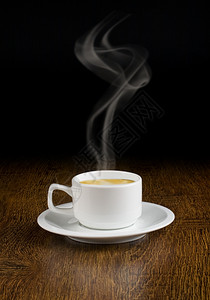 木桌上的咖啡杯和碟子黑暗背景图片