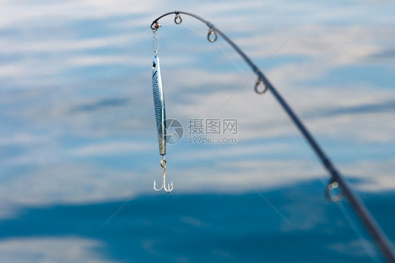 钓鱼饵与游击手对蓝海水表面的棍棒图片