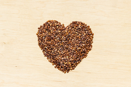 饮食保健概念木质表面形成的黄麦谷类心脏健康的无谷类食品图片