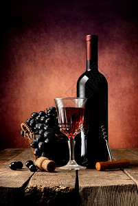 木桌上含葡萄和的酒图片