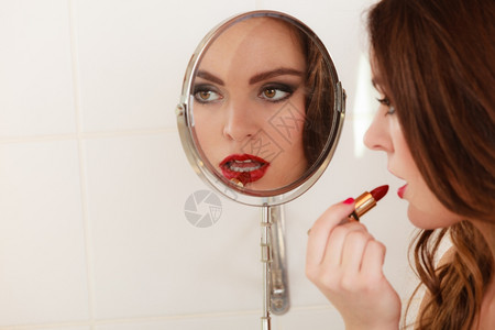 年轻女孩化妆在浴室化妆女人注意看照镜子图片