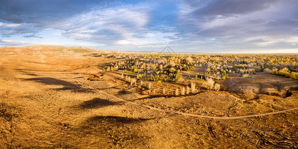 科罗拉多州柯林斯堡附近洛基山脉前线一带丘草原和居民区的山脚丘和居民区空中全景日出时落的风景照亮图片