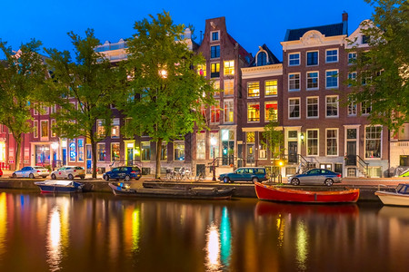 荷兰阿姆斯特丹运河的夜间城市景象典型的荷兰码头房屋和船只图片