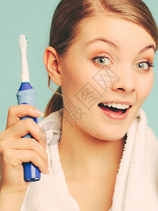 年轻女孩用牙膏刷白年轻女孩用电刷白牙快乐女人用膏清洗口腔关心牙科健康图片