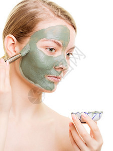 美容护皮肤化妆品和健康概念年轻女用面部粘土罩将泥涂在她脸上图片