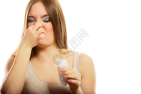 有趣的女孩用棍棒除臭剂遮住她的鼻子流汗背景图片