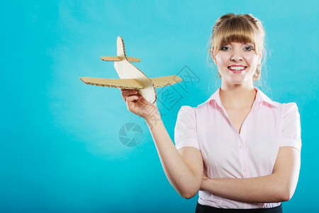 穿粉色衣服的女子手中拿着纸板飞机拍照背景图片