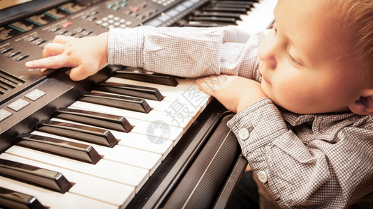 童年快乐和音小男孩玩黑数字硬盘钢琴合成器音乐图片