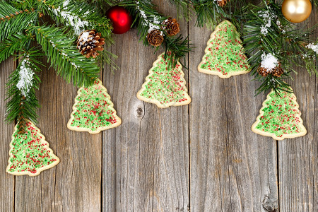 树形饼干的高角视图树形饼干有常青枝松果雪和锈木上的装饰品图片