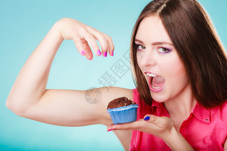 甜食糖让我们快乐笑的女人手持巧克力蛋糕松饼图片